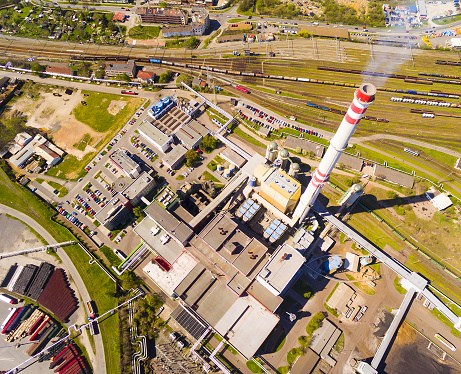 Aerial view of modern combined heat and power plant. Big chimney with sulphur removal unit. Heavy industry from above. Power and fuel generation theme.