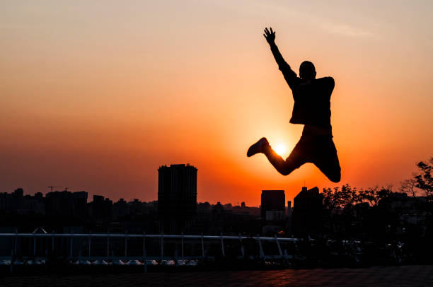 istock Silhouette of a young man on sunset background 835875338