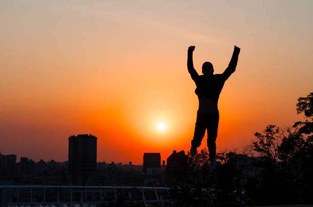 istock Silhouette of a young man on sunset background 835875360