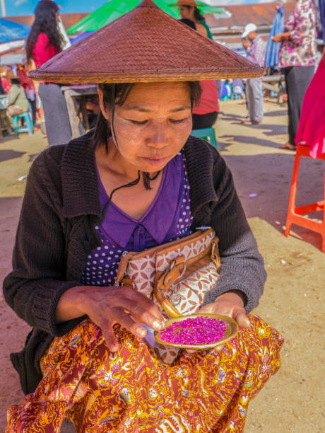 Mogok, Myanmar, December 2015 - The Burmese woman gems trader is offering her ruby merchandise to customers at Panchan hta-pwi gems market.