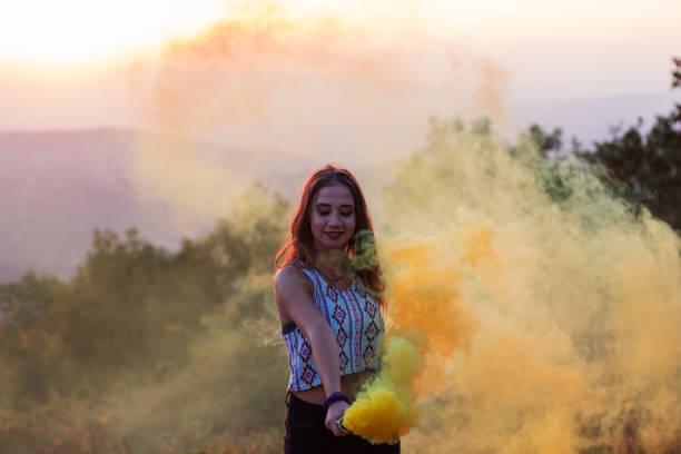 istock Girl in a yellow smoke cloud 835896424