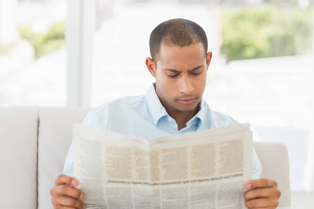 istock Businessman reading newspaper on the couch 835896432
