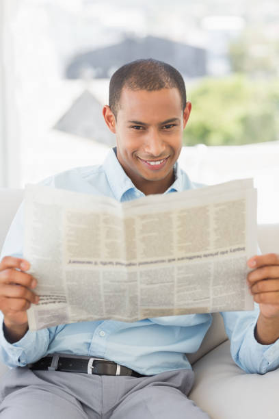 istock Happy businessman reading newspaper on the couch 835896486