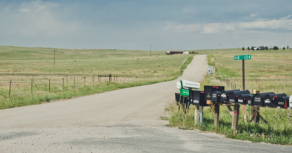 Bedrock City, Arizona, USA - June 20, 2017: village dirt road and the rustic old wooden mailboxes. Outskirts of an old farm in Arizona. Rural life in the USA. Obsolete communication system