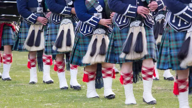 Traditional kilts and sporrans worn by bagpipe players during a performance by a Scottish Pipe Band