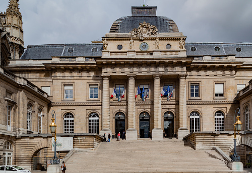 The facade of the Justice Palace with its four doric columns and clock, Ille de la Cite island, downtown Paris, France