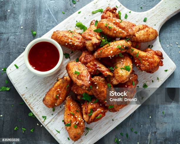 Baked Chicken Wings With Sesame Seeds And Sweet Chili Sauce On White Wooden Board Stock Photo - Download Image Now