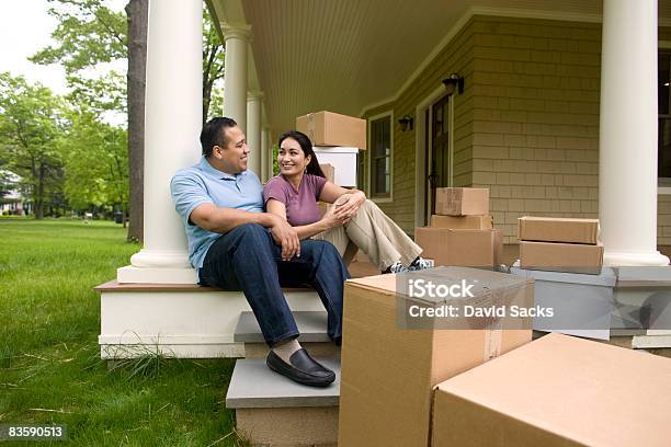 Happy Couple With Boxes Talking On Porch Stock Photo - Download Image Now - Home Ownership, Moving House, Latin American and Hispanic Ethnicity