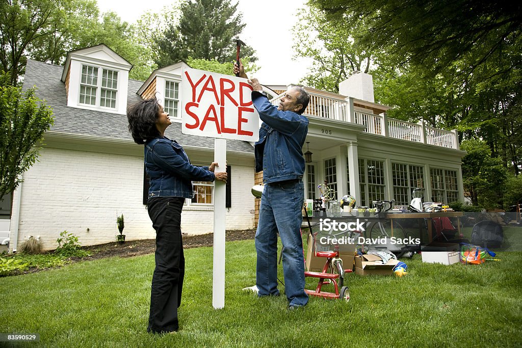 Mature couple putting up sign for Yard Sale  People Stock Photo