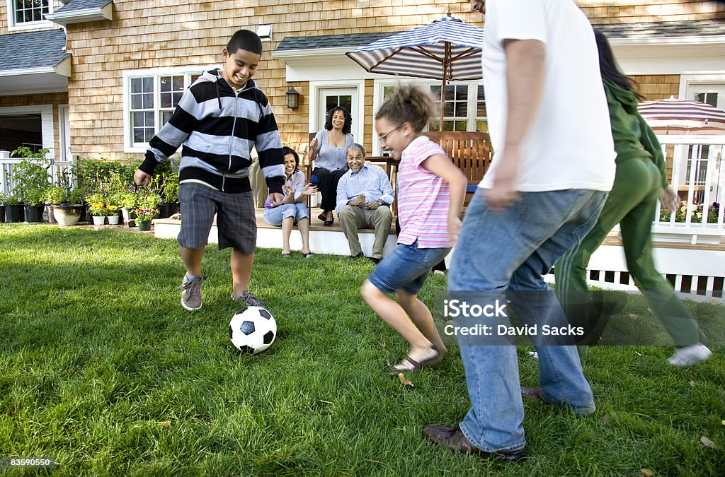 Familie Fußball spielen im Vorort Garten - Lizenzfrei Familie Stock-Foto