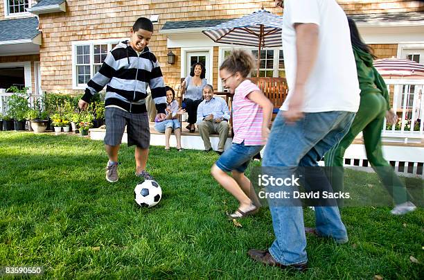 Familia Jugando Al Fútbol En La Zona Suburbana De Jardín Foto de stock y más banco de imágenes de Familia