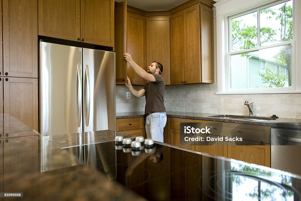 Contractor working on cabinets in new home  Examining Stock Photo
