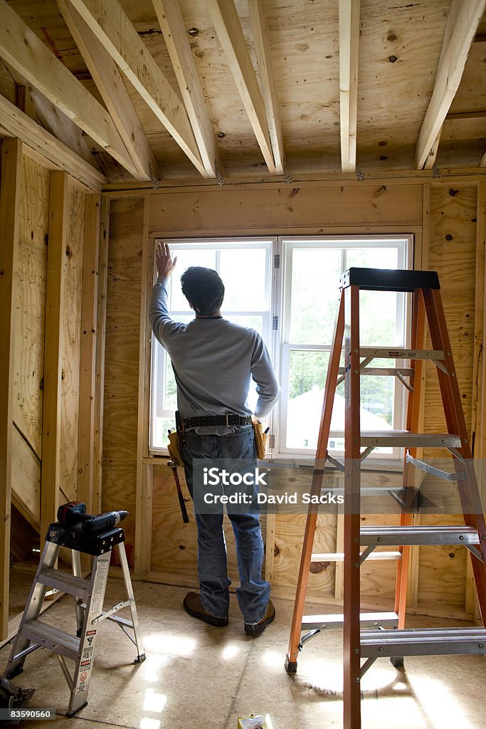 Contractor working on window in new home  Construction Industry Stock Photo