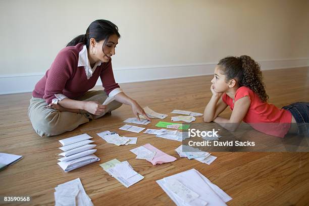 Madre Con Hija En Dirección A Través De Facturas Foto de stock y más banco de imágenes de Finanzas domésticas - Finanzas domésticas, Niño, Factura