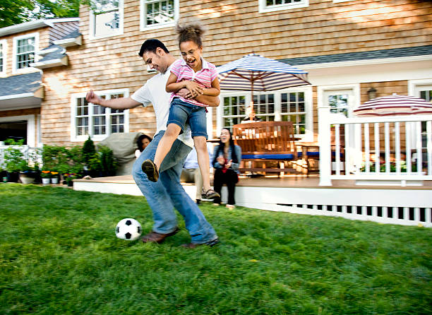 padre jugando al fútbol con hija en jardín - american football football focus on foreground team sport fotografías e imágenes de stock