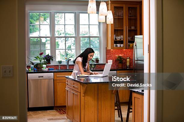 Woman In Kitchen On Laptop Stock Photo - Download Image Now - Chandelier, Domestic Life, One Woman Only