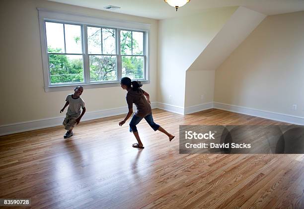 Foto de Crianças Correndo Na Sala Vazia Em Nova Casa e mais fotos de stock de Criança - Criança, Chão de Madeira, Correr