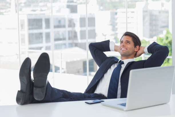 istock Successful businessman relaxing with his feet on his desk 835909894