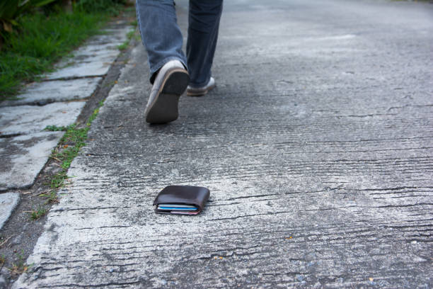 Wallet drop on the road when walking Wallet drop on the road when walking pavement ends sign stock pictures, royalty-free photos & images