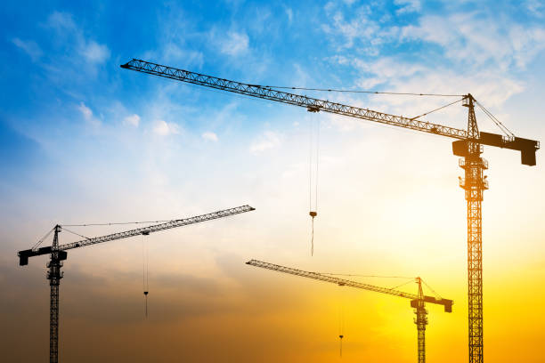 istock Abstract Industrial background with construction cranes silhouettes over amazing sunset sky 835911054