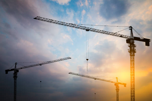 istock Abstract Industrial background with construction cranes silhouettes over amazing sunset sky 835911084
