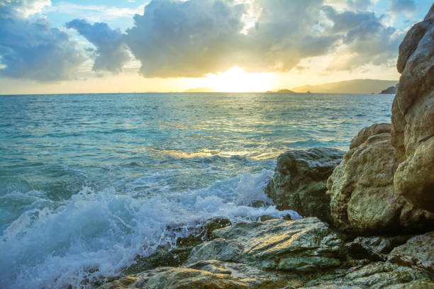 istock Splash waves hit rocks with the beautiful sunset and sky . 835919498