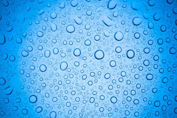 Rain droplets on blue glass background, Water drops on glass.