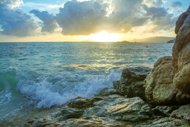 istock Splash waves hit rocks with the beautiful sunset and sky . 835921870