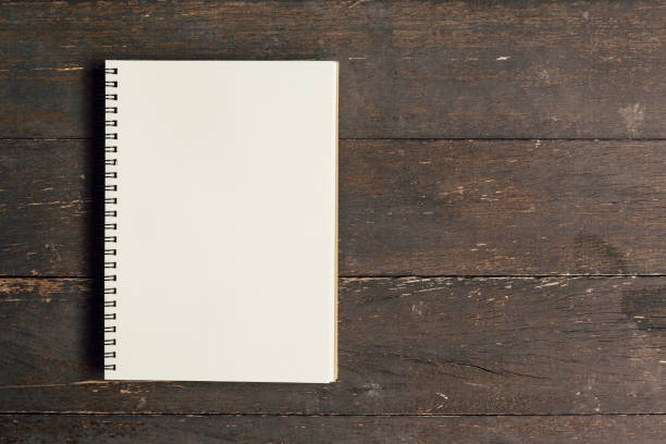 istock Brown book open on wood table background with space. 835922260