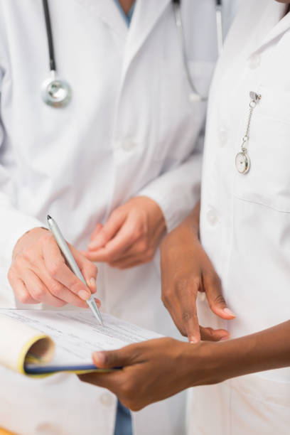 istock Doctor and nurse going over file on clipboard together 835926240
