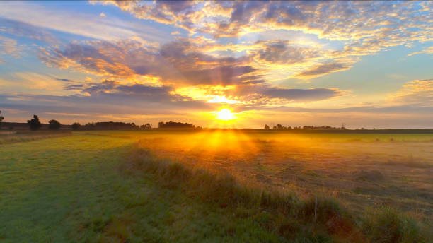 istock Amazing sunrise bursts through clouds over foggy Midwest fields. 835934550