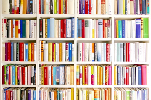 White library book shelves packed with colorful books