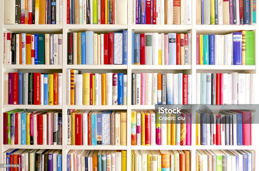 White library book shelves packed with colorful books White library book shelves Bookshelf Stock Photo