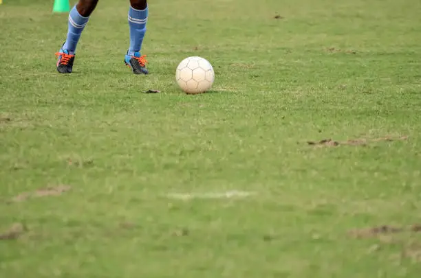 Soccer player is running to kick ball