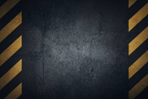 Old black grungy metal plate surface with yellow warning stripes Old black grungy metal plate surface with yellow warning stripes. Building, construction. Banner, place for text. dark road stock illustrations