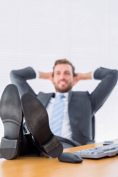 istock Relaxed businessman sitting with legs on desk 835949934