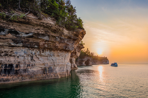 View of tour boat and and Pictured Rocks National Lakeshore on Lake Superior at sunset.