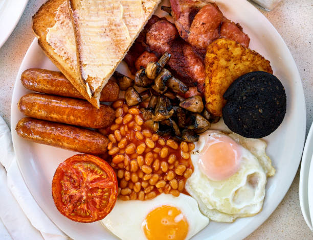Traditional full english breakfast Traditional full english breakfast. Fried eggs, baked beans, bacon, sausages and toasts english breakfast stock pictures, royalty-free photos & images