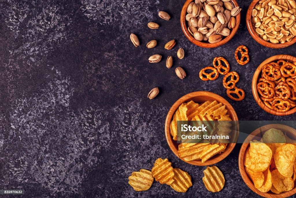 Snacks in a bowls on stone background. Snacks in a bowls on stone background. Top view, copy space. Appetizer Stock Photo