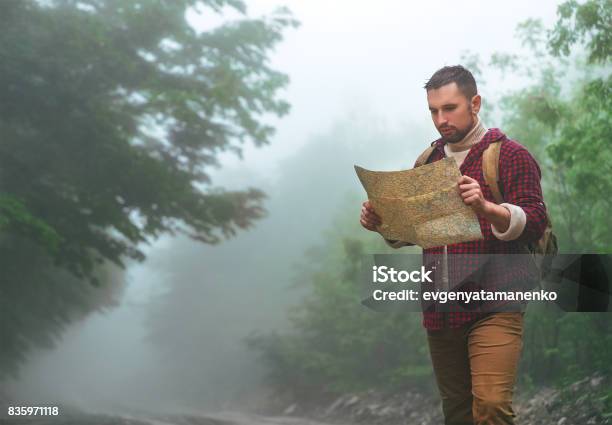 Foto de Turismo Masculino Nos Bosques Nas Montanhas Com Um Mapa e mais fotos de stock de Sobrevivência