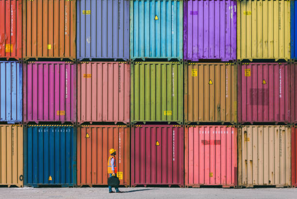 Maintanence worker working with cargo containers Engineer man with yellow crash helmet and worker west checking cargo freights in front of colorful cargo container stacks in shipping port industrial ship photos stock pictures, royalty-free photos & images