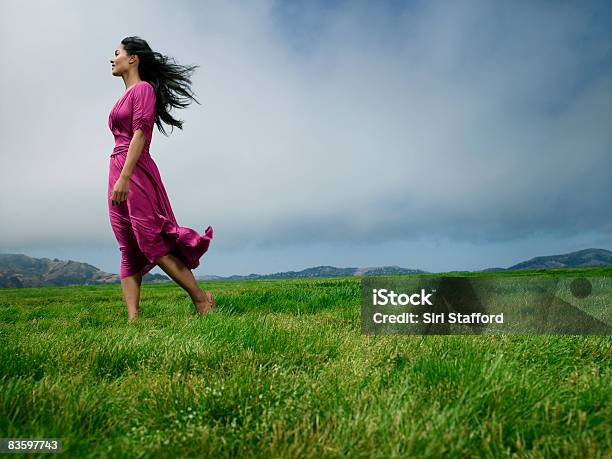 Woman Standing In Field Barefoot Stock Photo - Download Image Now - One Woman Only, Wind, Grass