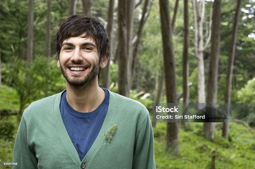 Man in forest, smiling, portrait Man in forest with cypress trees in background, smiling, portrait Environmental Conservation Stock Photo