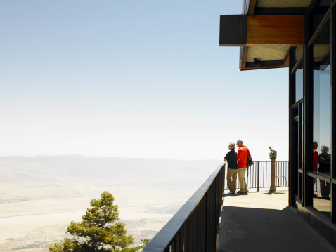 Couple standing on lookout platform, Palm Springs in the distance