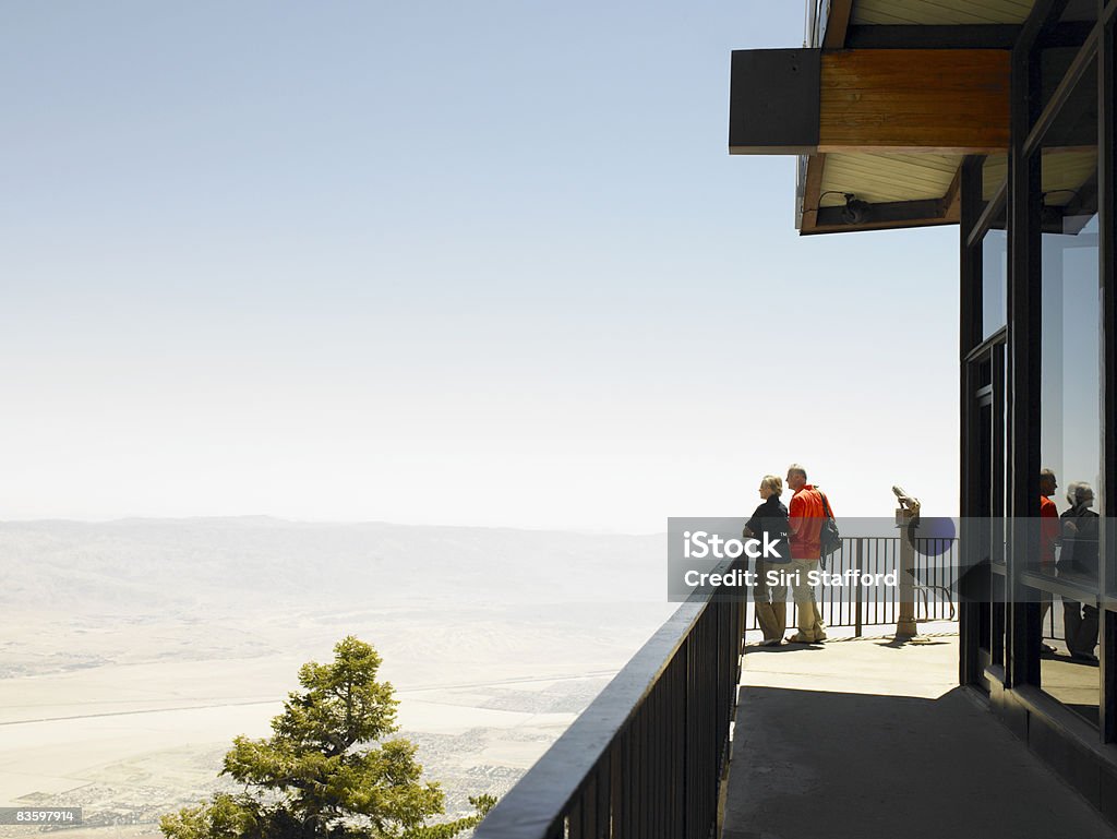 Mature Couple standing on lookout platform Couple standing on lookout platform, Palm Springs in the distance Palm Springs - California Stock Photo