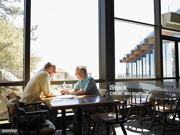 Mature Couple Holding Hands In Restaurant Stock Photo - Download Image Now - Restaurant, Retirement, Planning