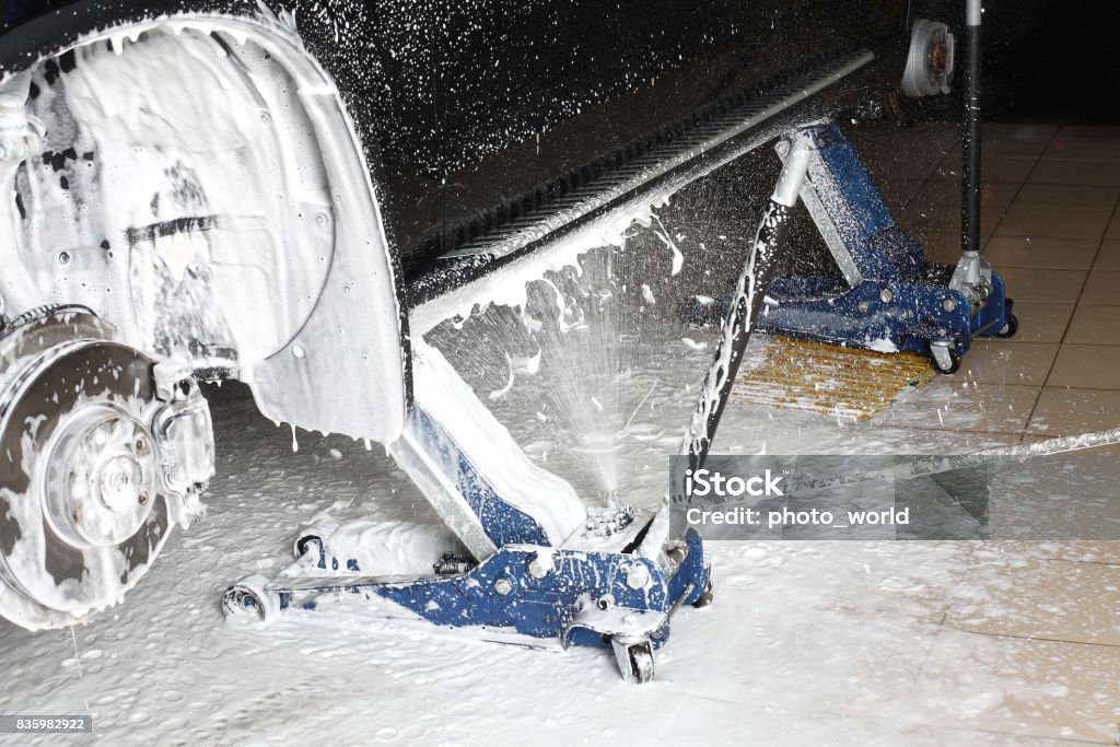 Car service. Washing of a wheel niche under pressure Washing of the wheel niche foam under pressure. Brake Stock Photo
