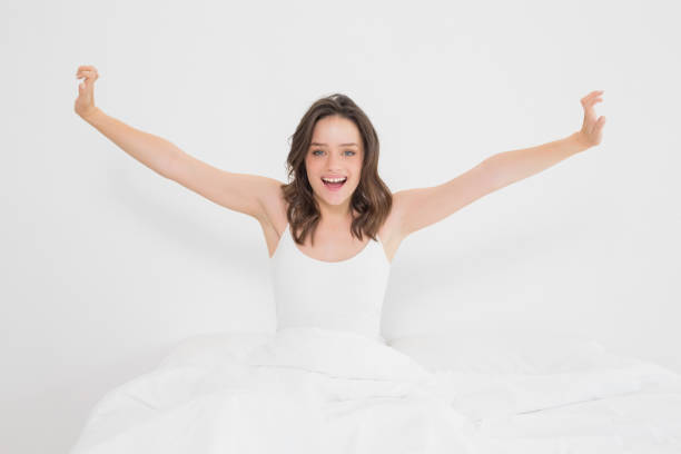 istock Smiling woman stretching her arms in bed 835987340