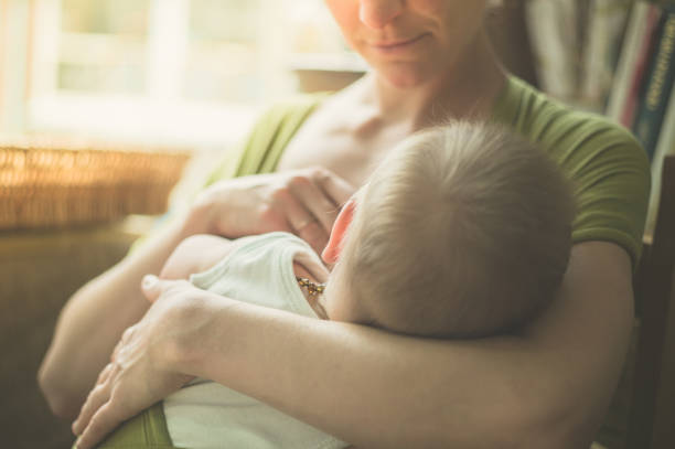 Mother breastfeeding baby in a cafe stock photo