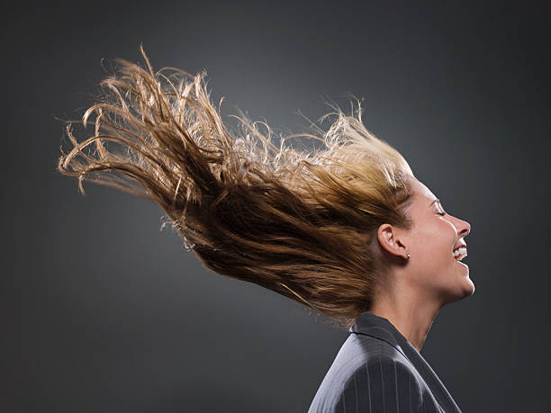 femme d'affaires de cheveux dans le vent souffle - cheveux dans le vent photos et images de collection